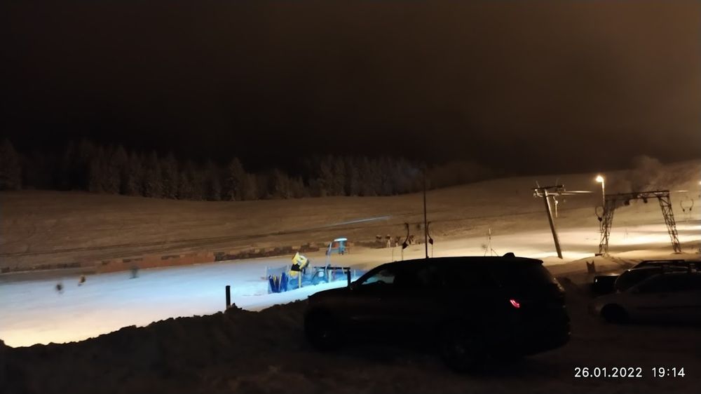 Widok na oświetlony stok w Olešnice po zmroku.