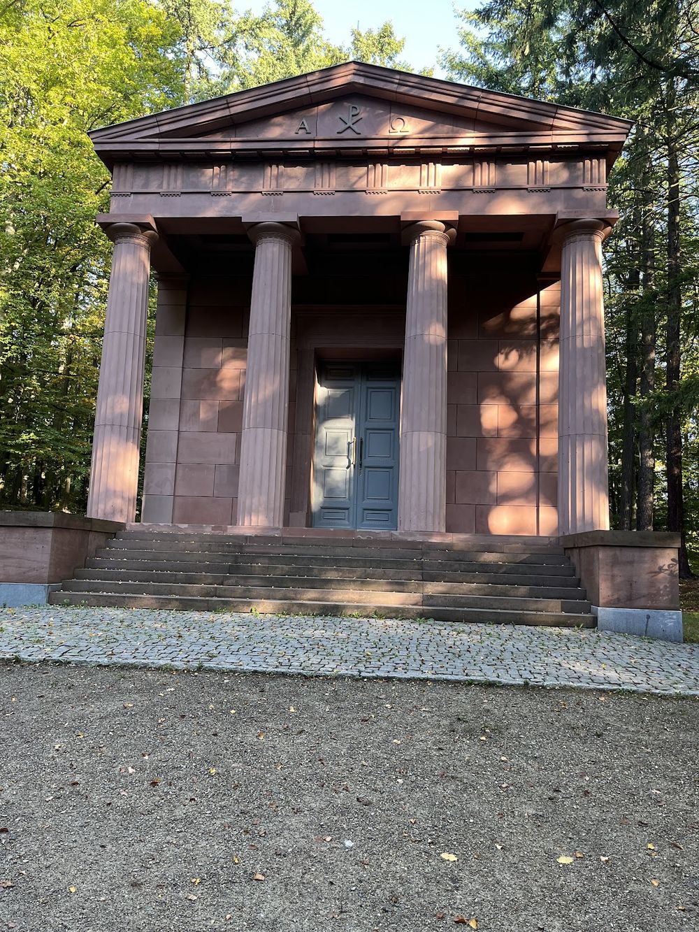 Zabytkowe mauzoleum w parku pałacowym w Kamieńcu pod ośnieżonymi drzewami.