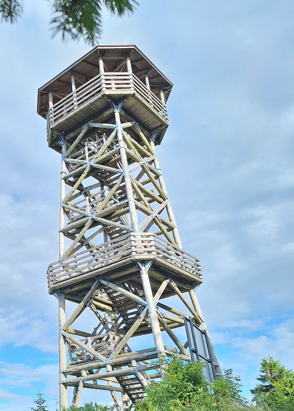 Drewniana wieża widokowa na Czerńcu w zimowej szacie, otoczona ośnieżonym lasem.