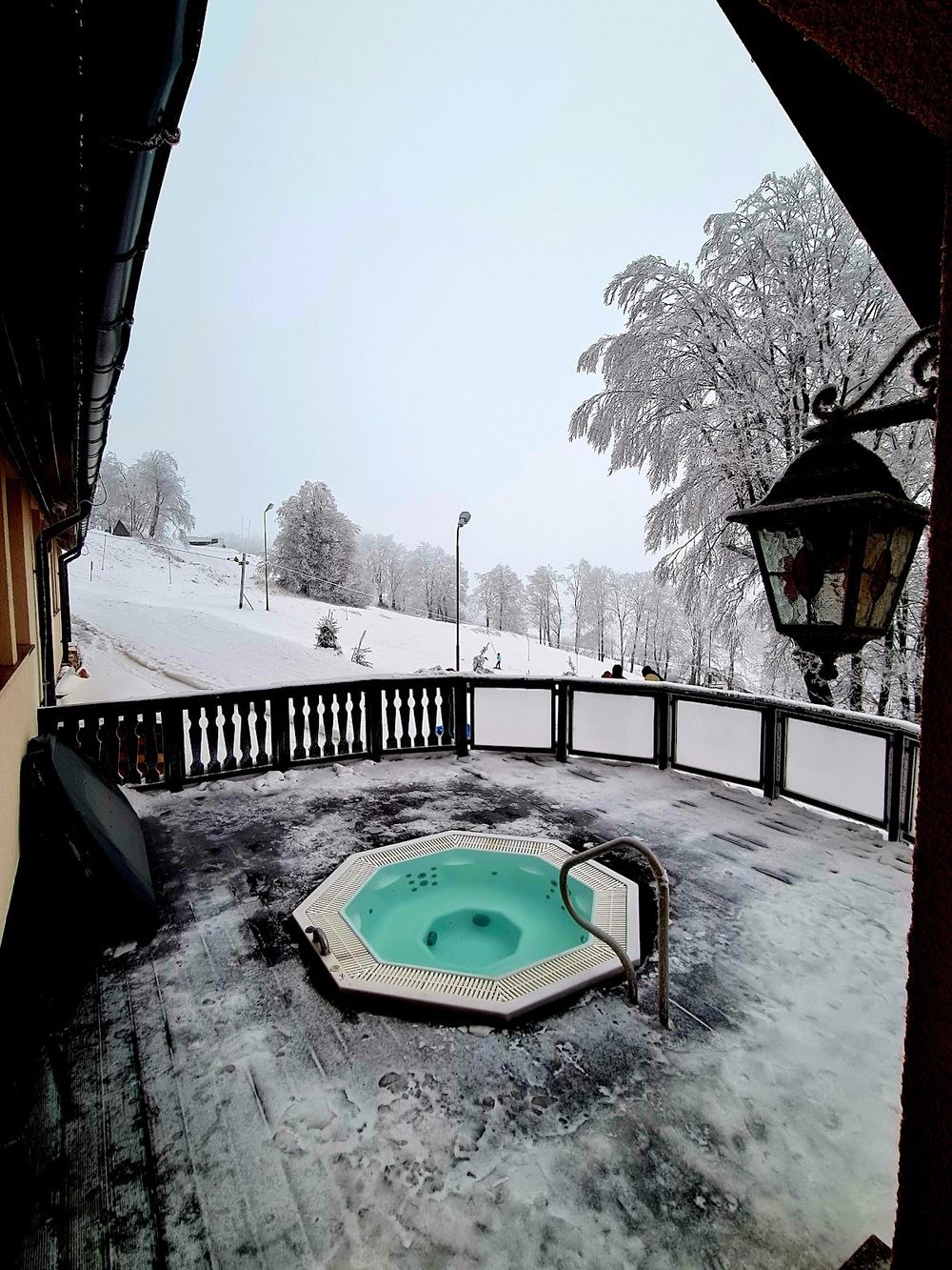 Widok z hotelowego balkonu na ośnieżone szczyty Gór Orlickich o świcie.