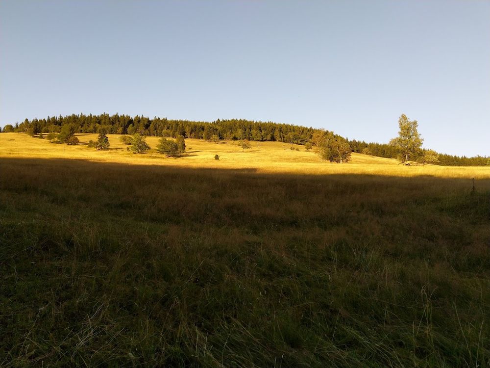 Widok na góry o zachodzie słońca pod niebem o świcie pod słońcem.