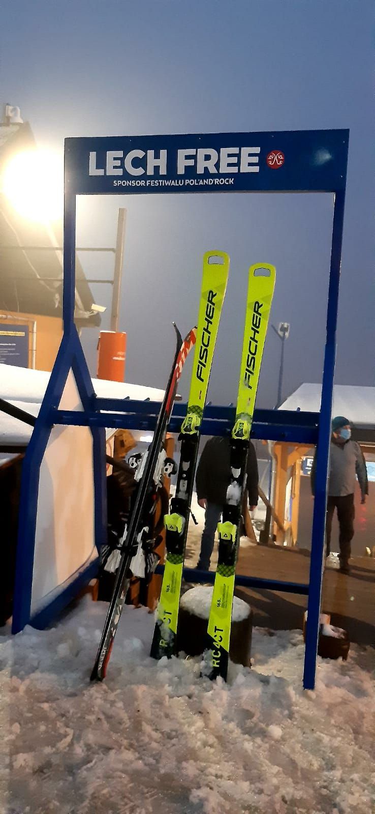 Mały narciarz pewnie stawiający pierwsze kroki na stoku pod okiem instruktora.