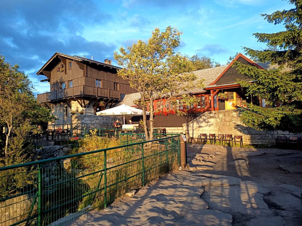 Wieczorna cisza na ganku Schroniska na Szczelińcu pod ciemniejącym niebem.