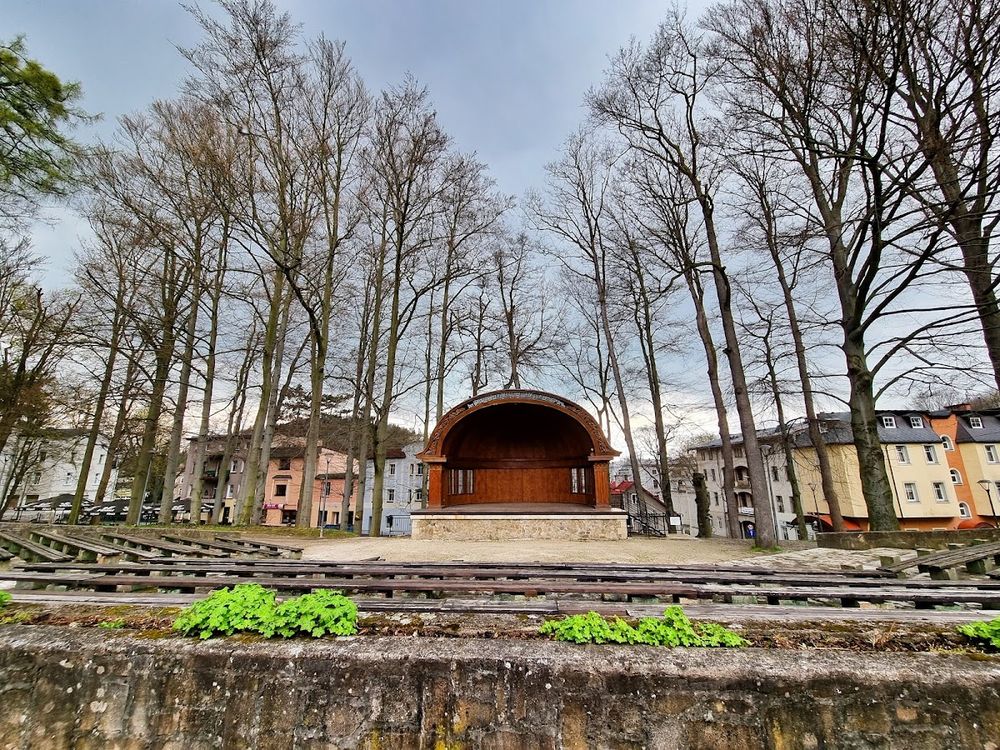 Biała altana Muszli Koncertowej w sercu lądeckiego parku zimą.