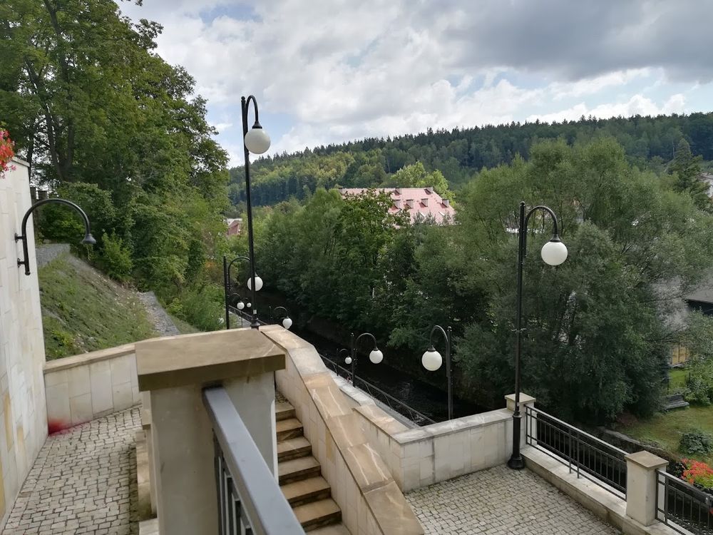 Nastrojowe schody wejściowe do sanktuarium w otoczeniu starych drzew.