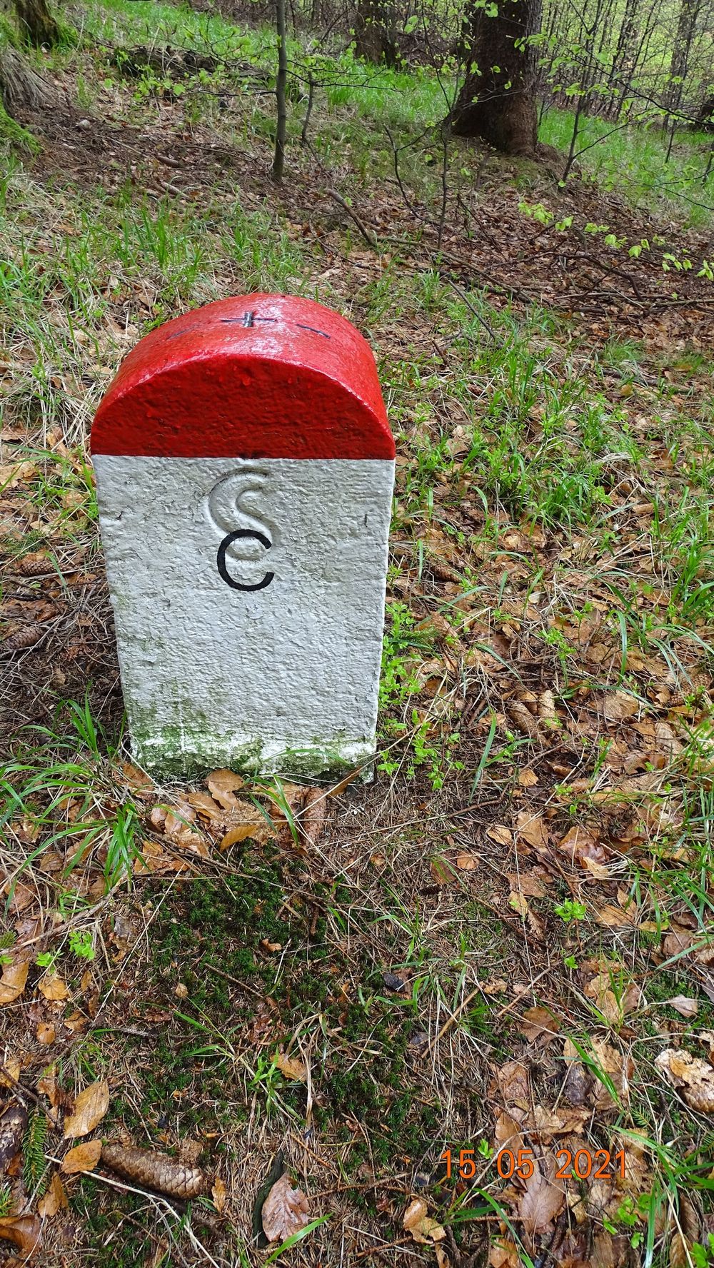 Historyczny słupek graniczny na ośnieżonym grzbiecie.