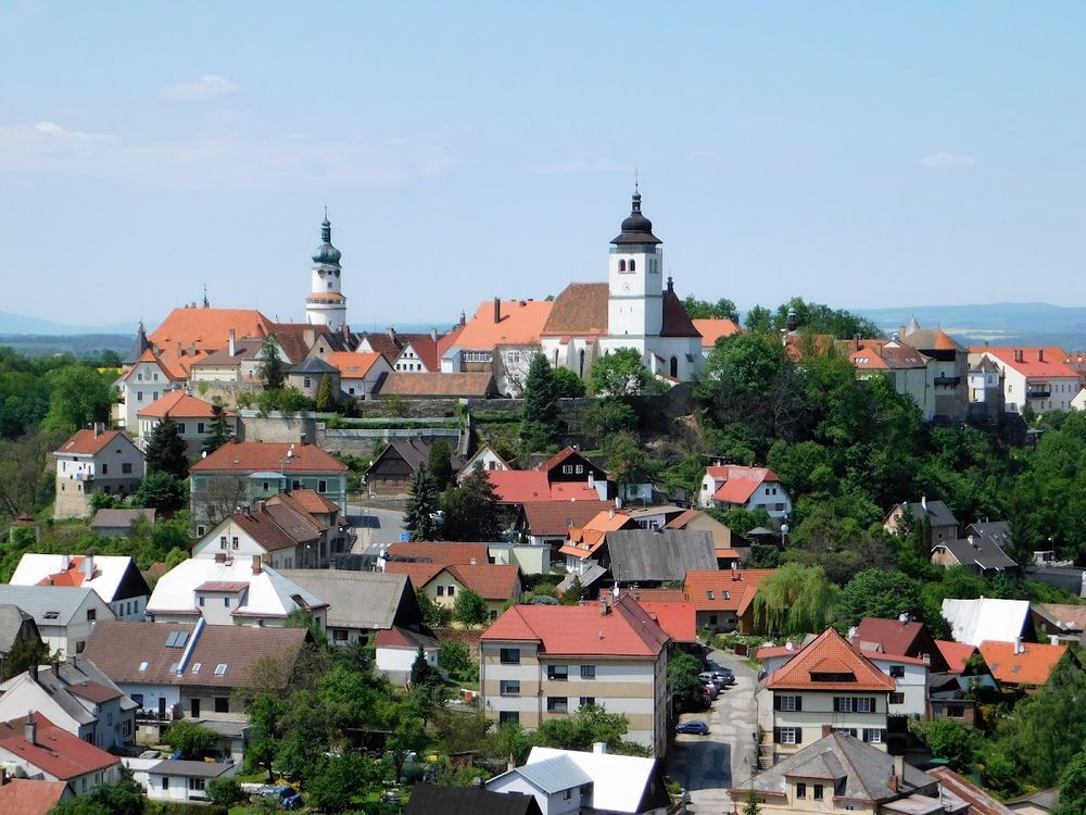 Widok na wieś z kościołem na wzgórzu pod niebem o świcie.