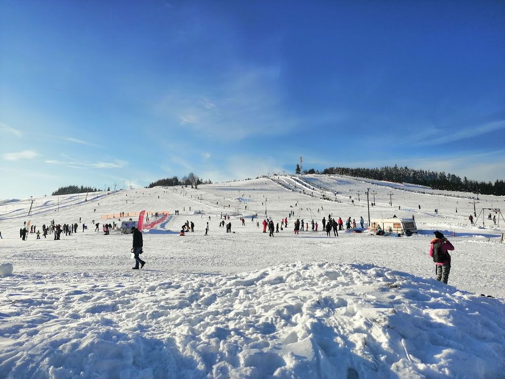 Stok narciarski na Przełęczy Sokolej tętniący życiem pod zimowym słońcem.