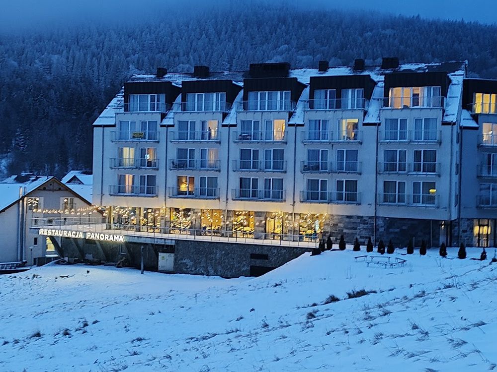 Nowoczesna architektura hotelu Czarna Góra Resort kontrastująca z błękitem zimowego nieba.