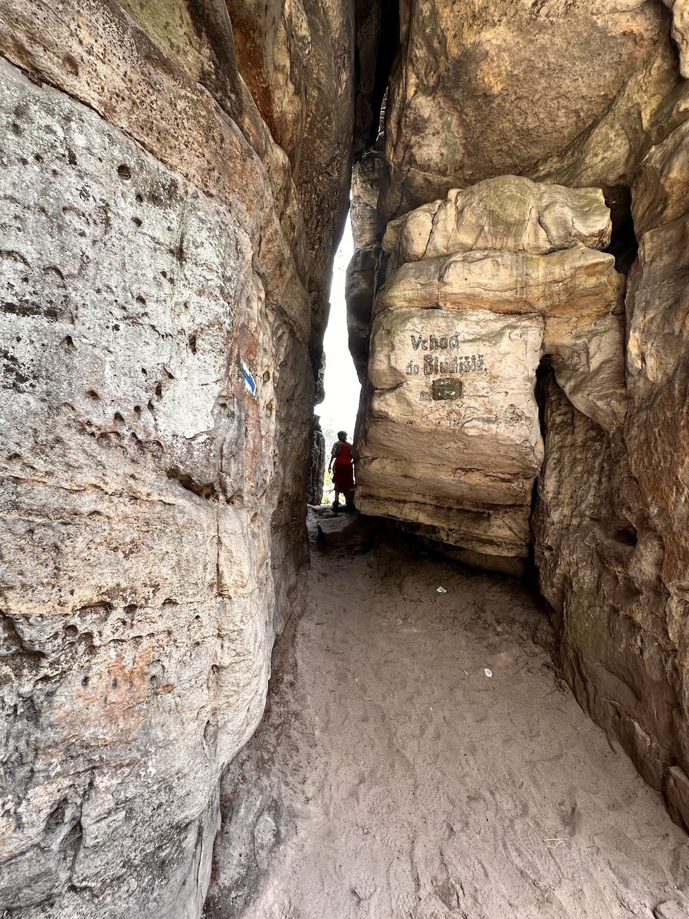 Wąskie przejście w szczelinie skalnej na Ostašu, pionowe ściany piaskowca.