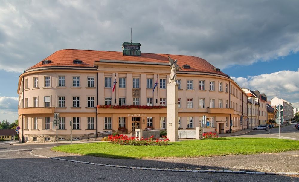 Okazały gmach szkoły lub urzędu pod błękitnym niebem pod słońcem.