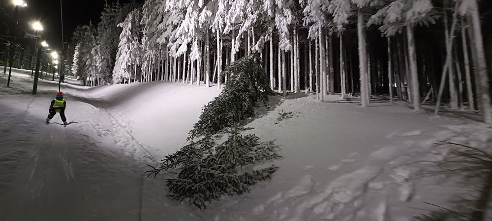 Nocne oświetlenie kurortu zimowego w Pisarzowicach pod niebem o świcie.