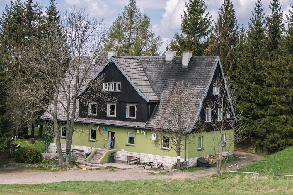 Budynek Schroniska Pasterka zimą o zmierzchu pod gwieździstym niebem.