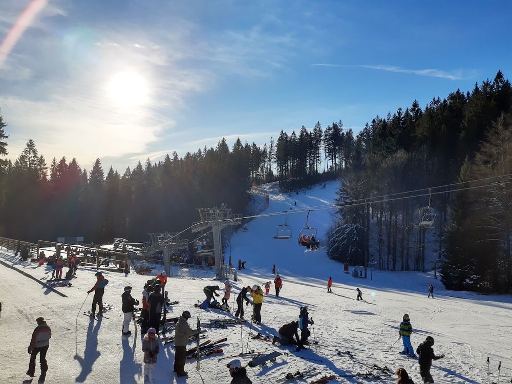 Szeroka panorama tras narciarskich w Ski center Říčky pod błękitnym niebem.