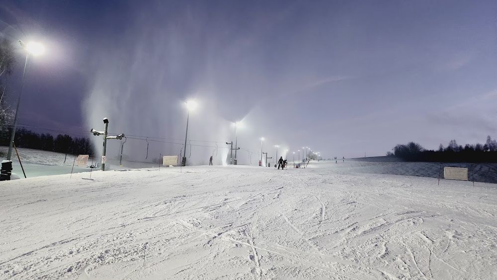 Narciarze przygotowujący się do zjazdu w promieniach zimowego słońca.