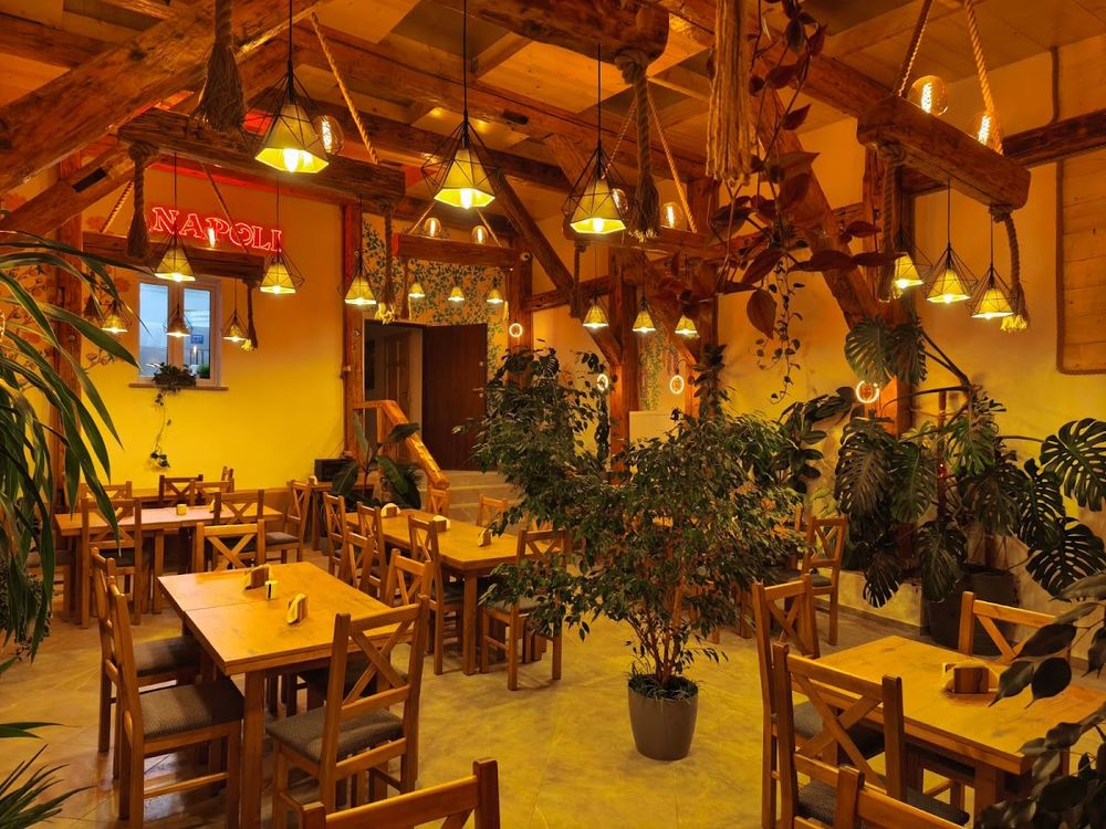 Stylowe wnętrze restauracji Napoli z ciepłym, oświetleniem.