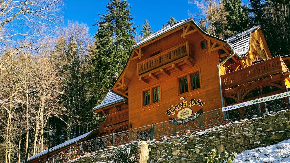 Regionalna architektura Alpejskiego Dworu otulona śnieżną pierzyną.