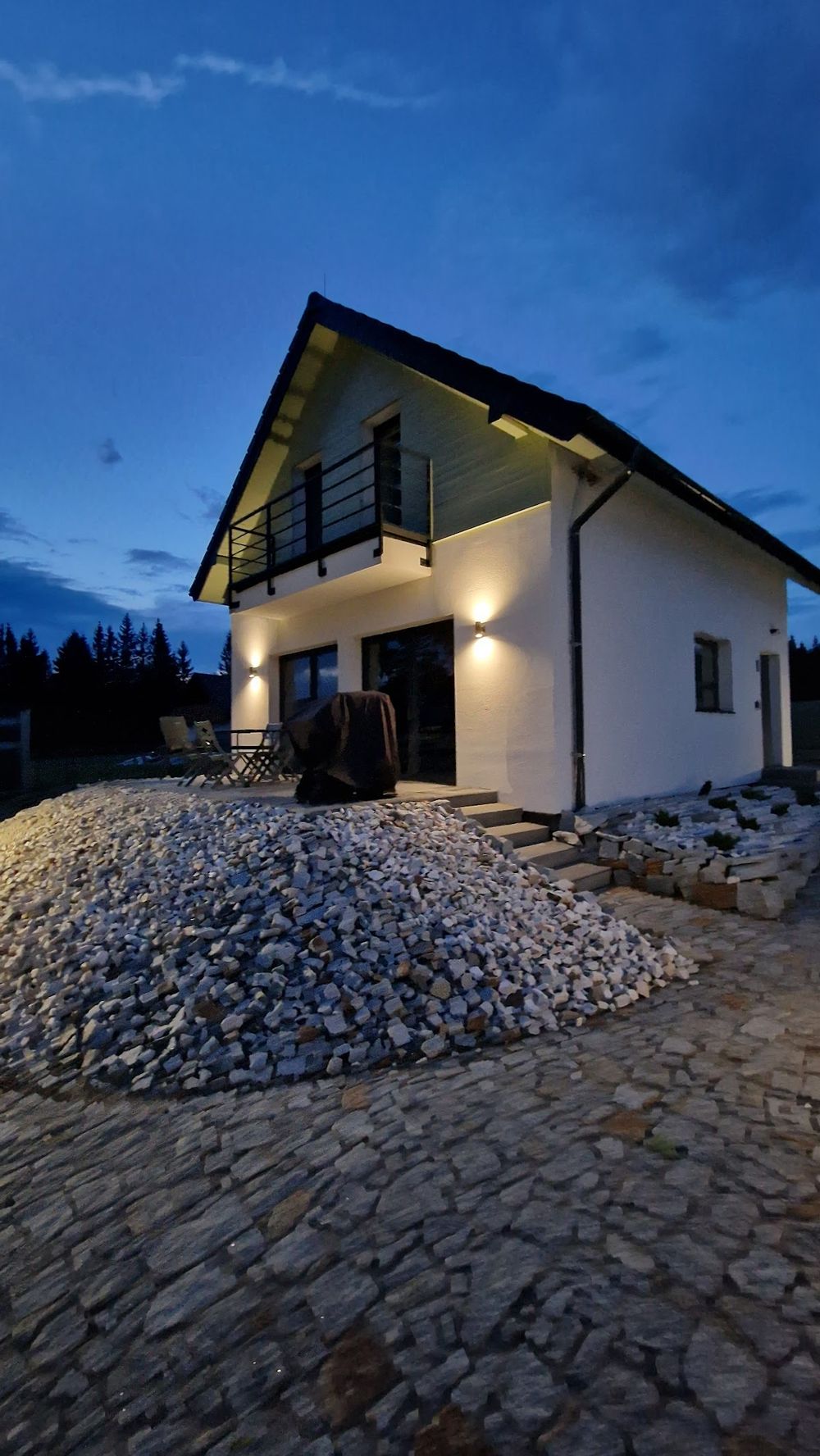  oświetlenie domków All Season nocą na tle ośnieżonych szczytów.