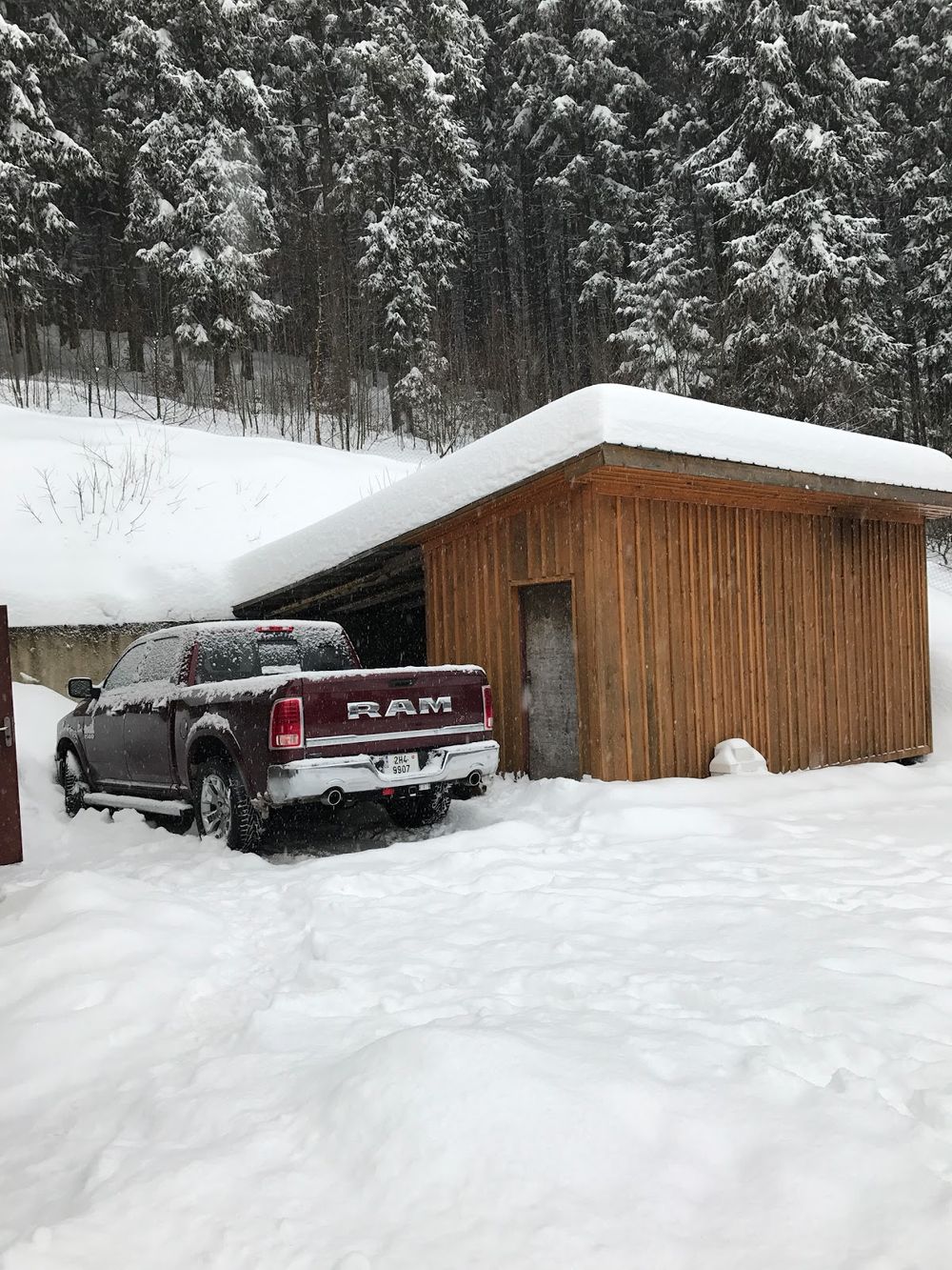 Drewniana wiata wypoczynkowa przy pensjonacie Jílovanka w zimowej scenerii.