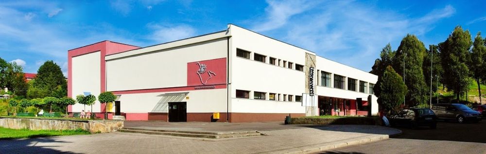Budynek Miejskiego Ośrodka Kultury w Nowej Rudzie o jasnej elewacji o zachodzie słońca.