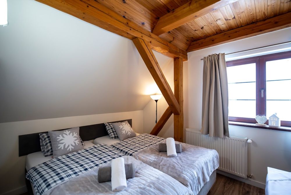 Przytulny pokój na poddaszu Jakubcówki – elegancki styl i górska nastrojowość.