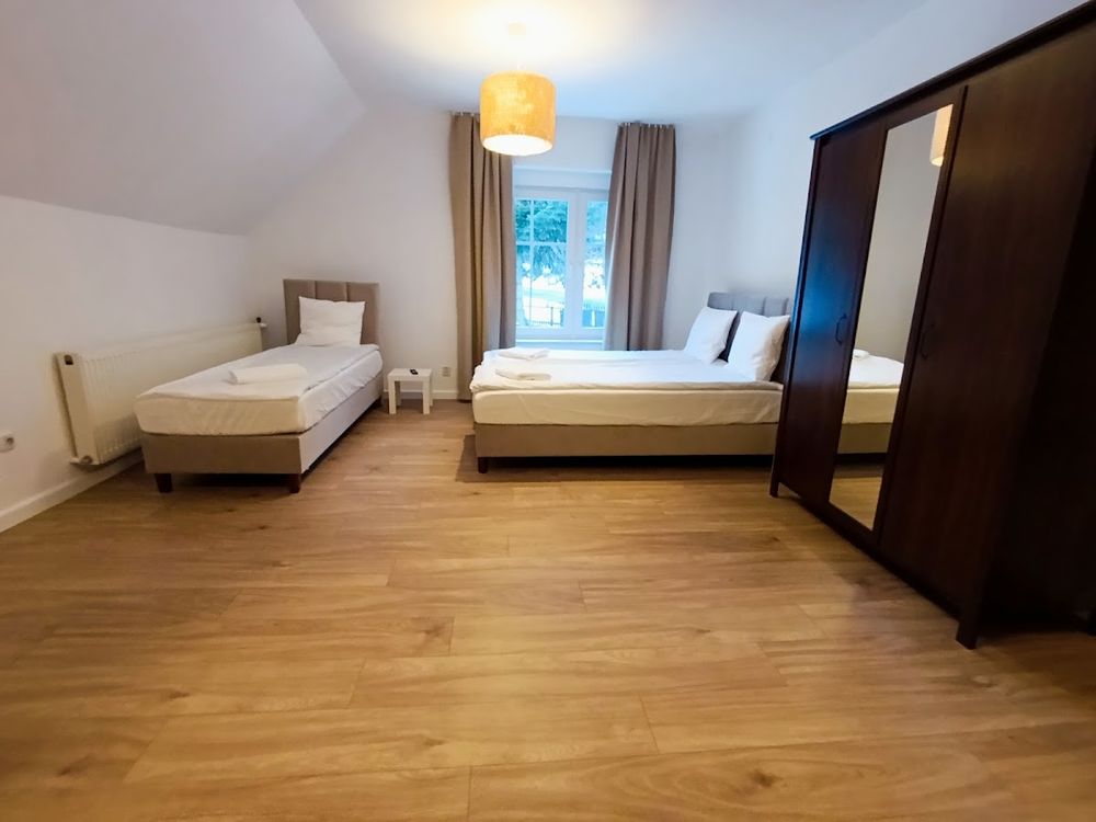 Komfortowy pokój w Pensjonacie Sokolec oświetlony blaskiem lamp.