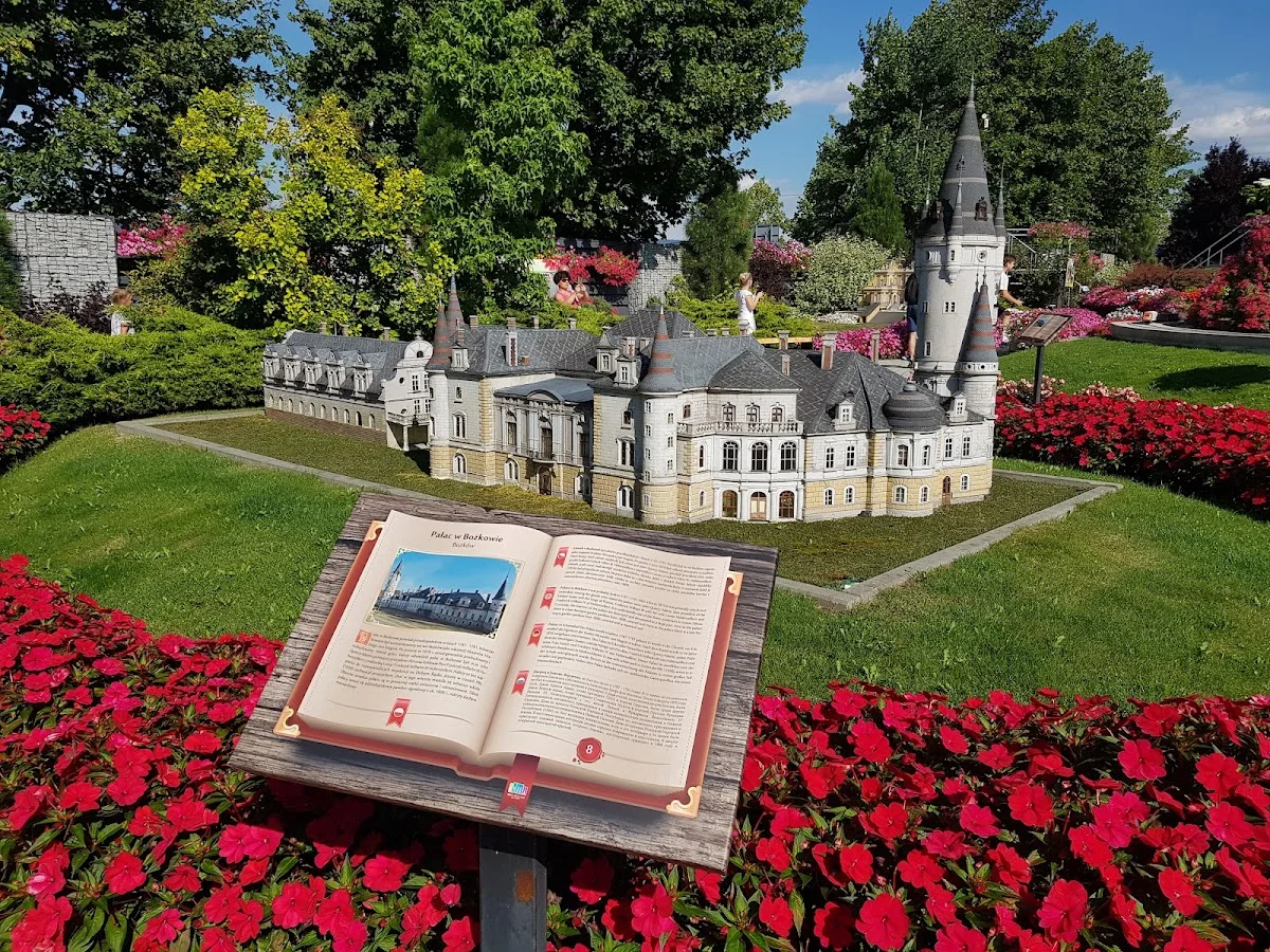 Górski krajobraz z miniaturą zamku na szczycie.