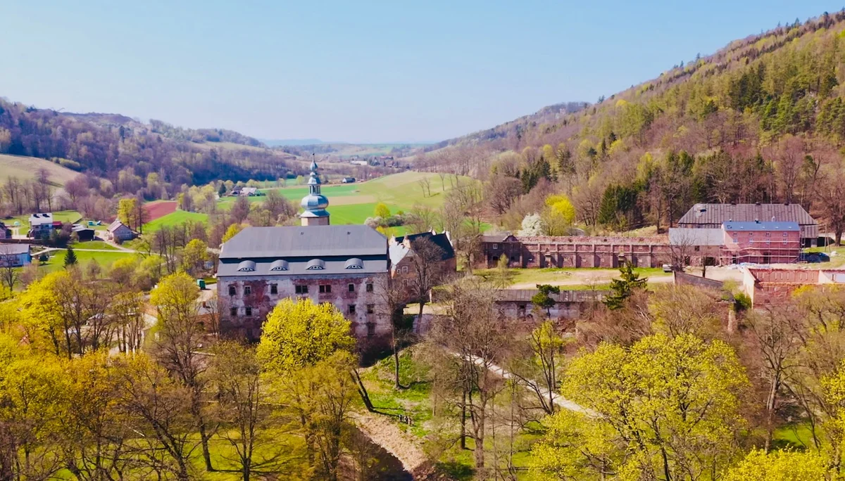 Panorama doliny z oświetlonymi budynkami wieczorem.
