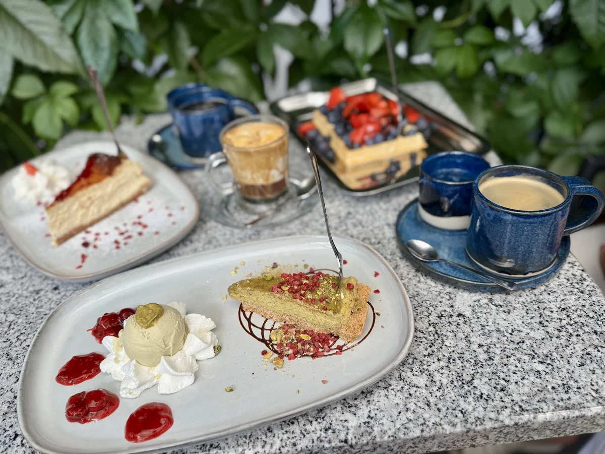 Zestaw deserów i kawa na eleganckim stole.