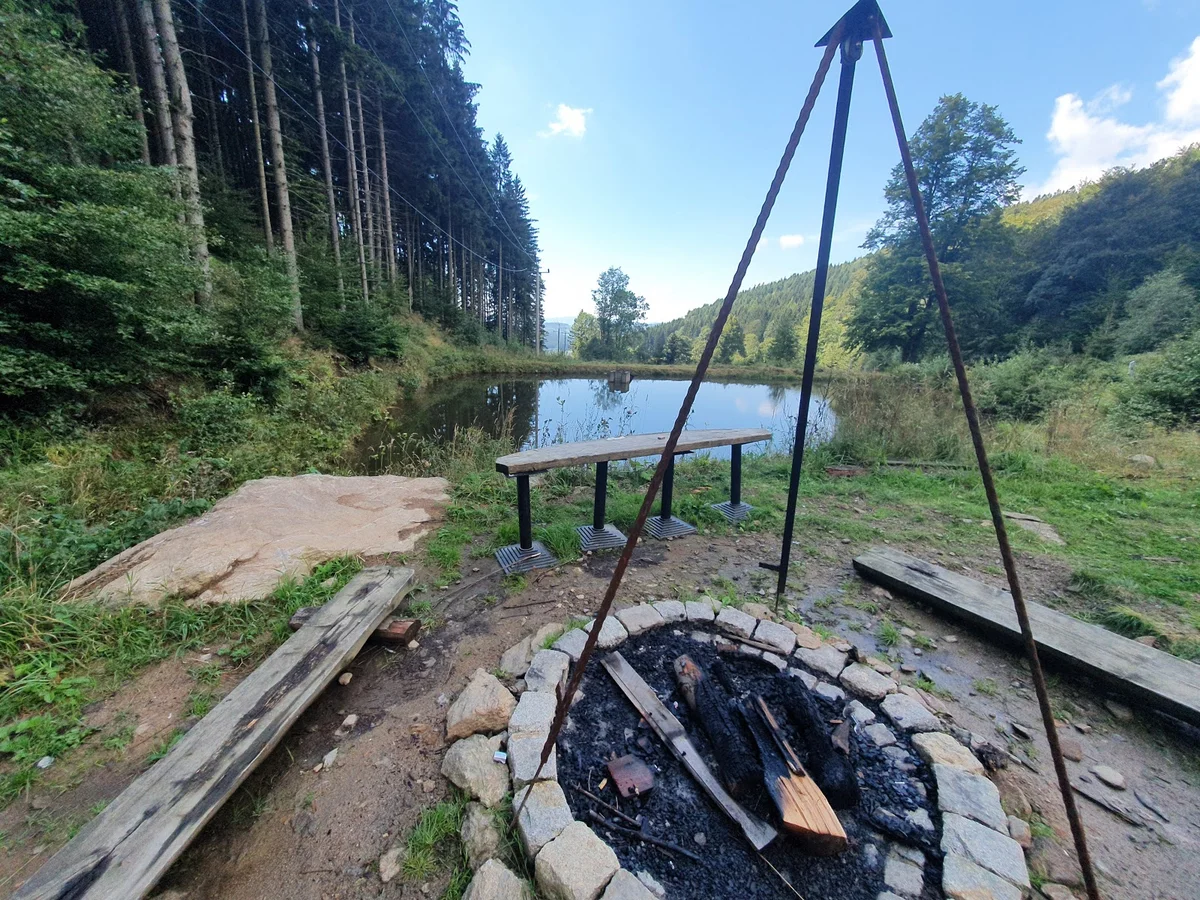 Miejsce na ognisko z wiszącym kociołkiem w lesie.
