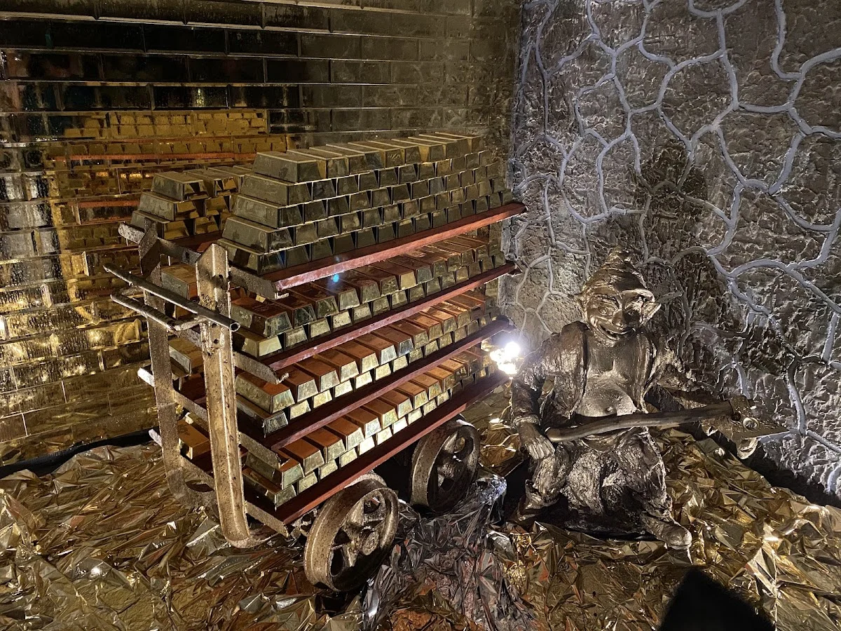 Oświetlone wnętrze zabytkowej kopalni z rzędami lamp nocą.