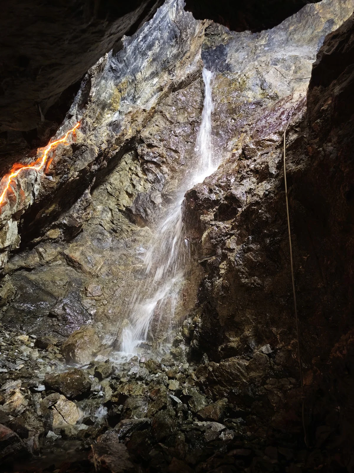 Górski potok spływający po skałach pod lasem o świcie.