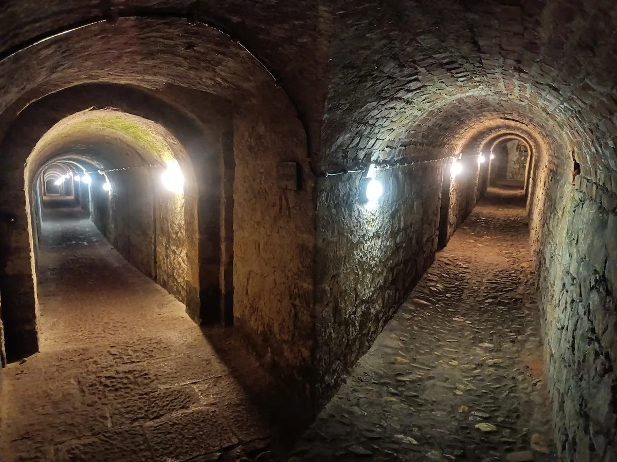 Oświetlony korytarz w kopalni o zmroku ze złotymi lampami nocą.