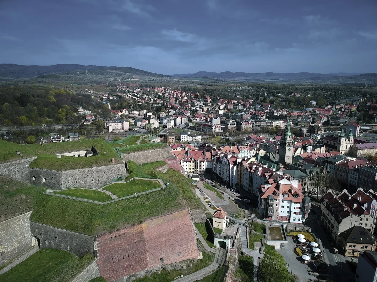 Panorama miasteczka z wieżą kościelną o zachodzie słońca pod niebem.
