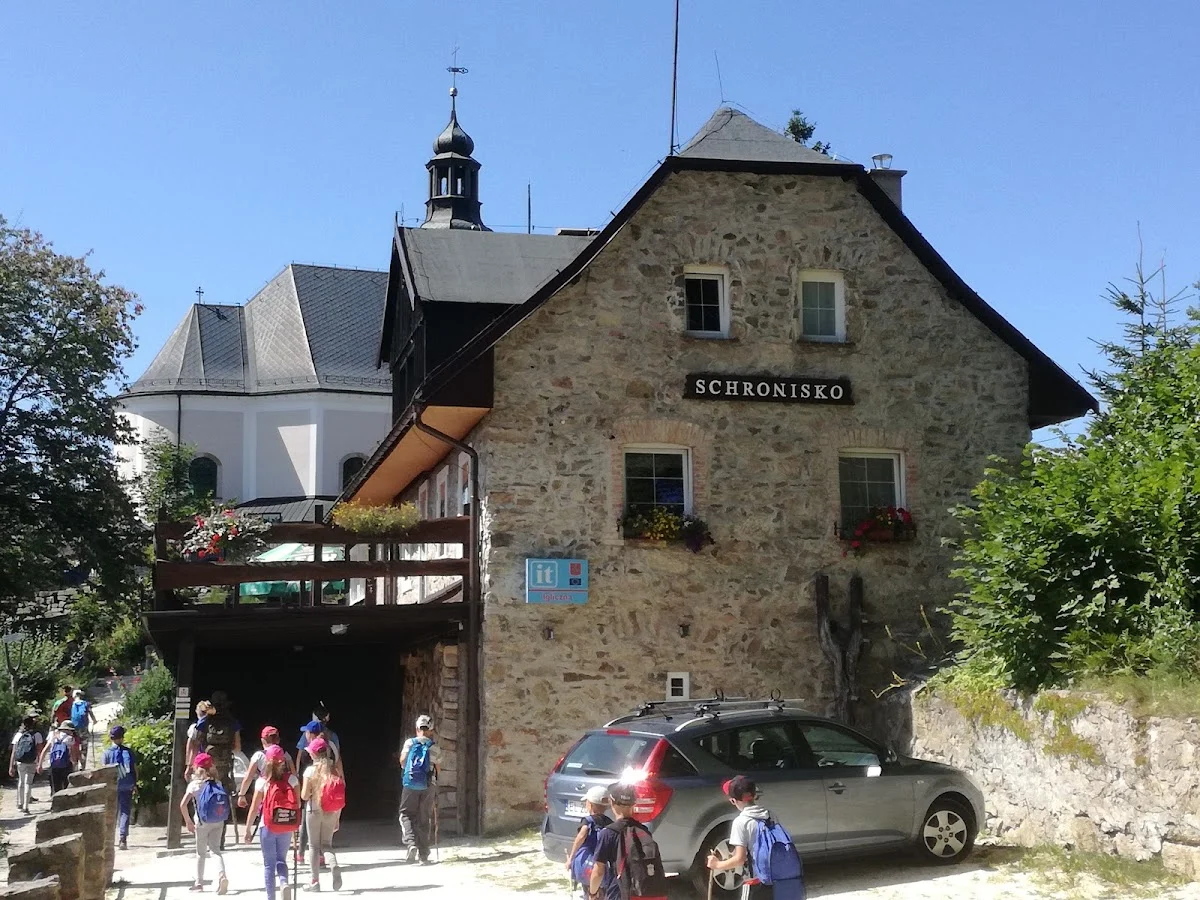 Schronisko górskie o tradycyjnej architekturze pod słońcem pod niebem.