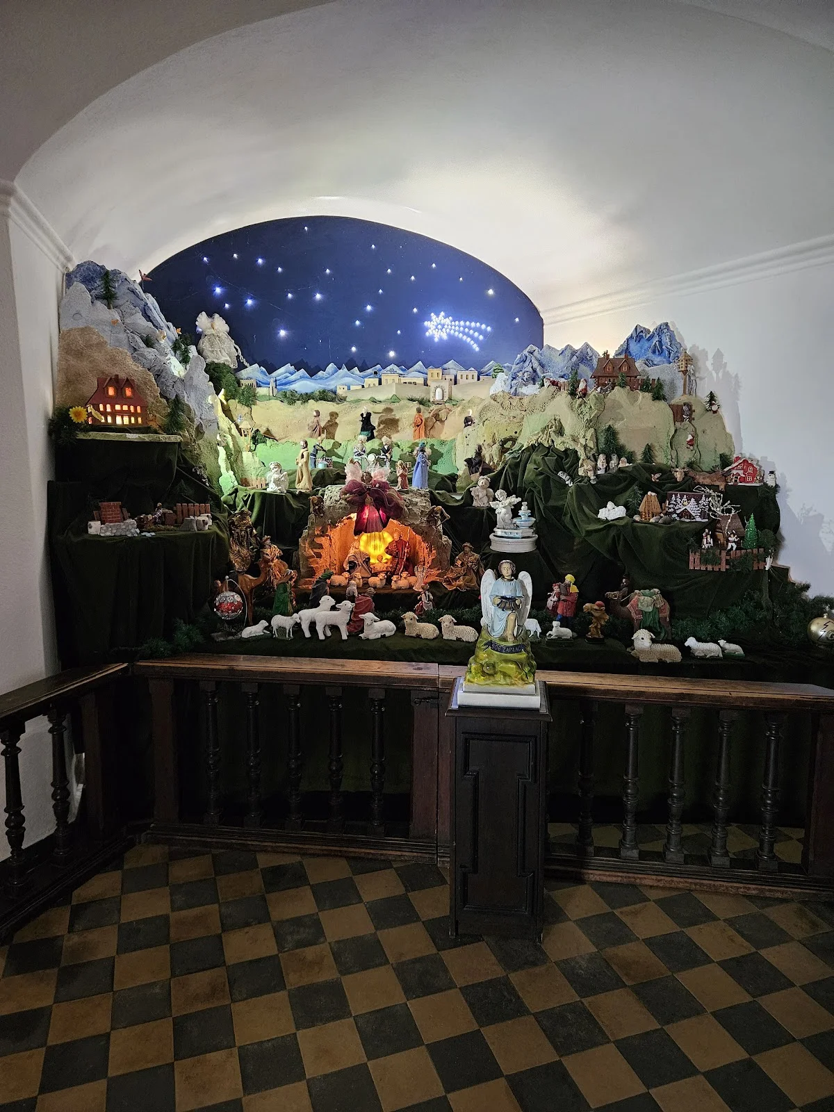 Kolorowa szopka z wieloma figurami o tradycyjnym wystroju pod słońcem.