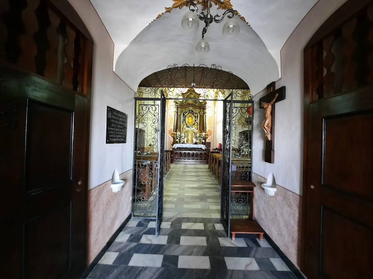 Widok na ołtarz z kruchty kościoła o tradycyjnym wystroju pod słońcem.