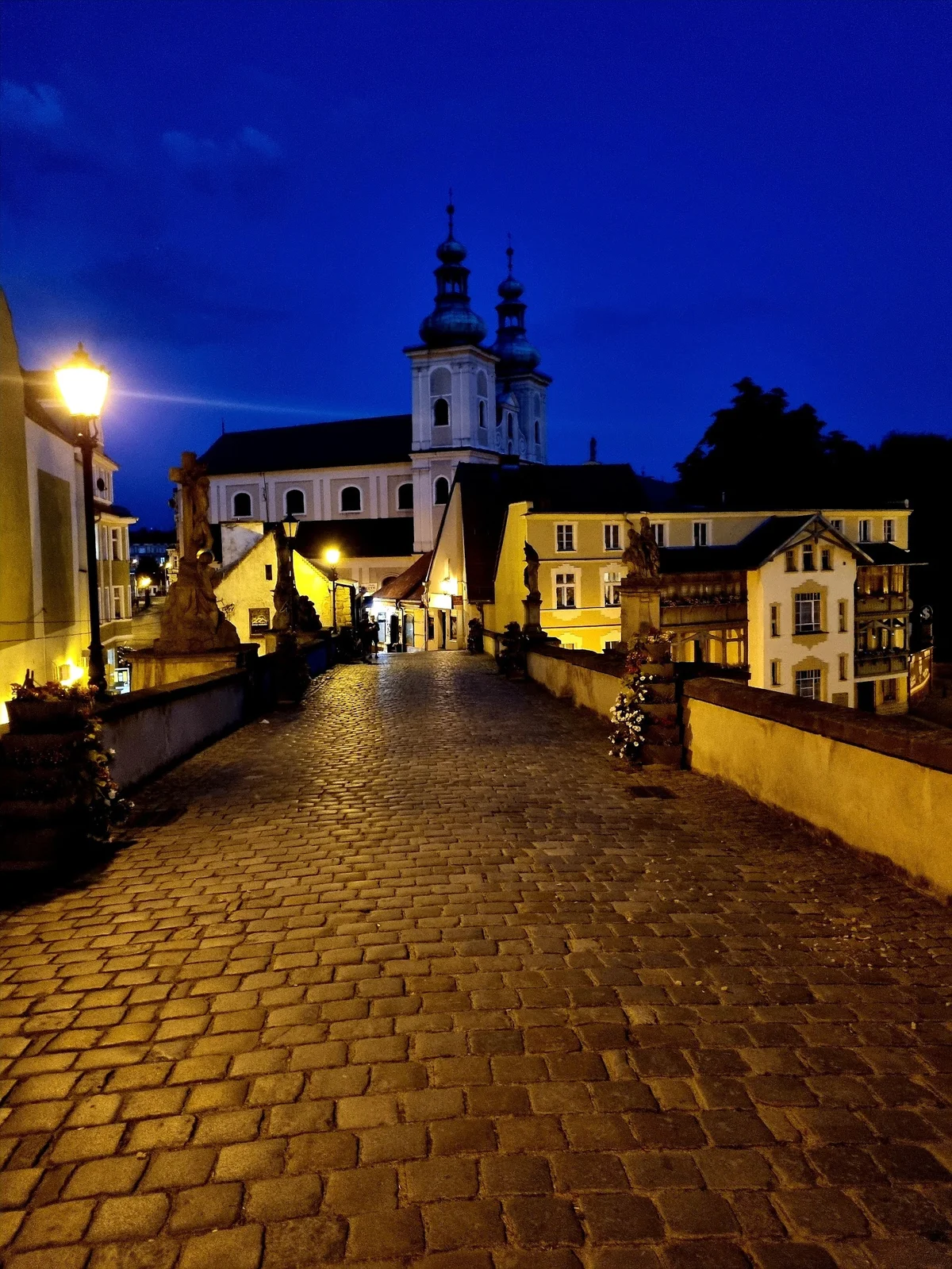 Oświetlone nabrzeże rzeki nocą o wysokim standardzie pod niebem.