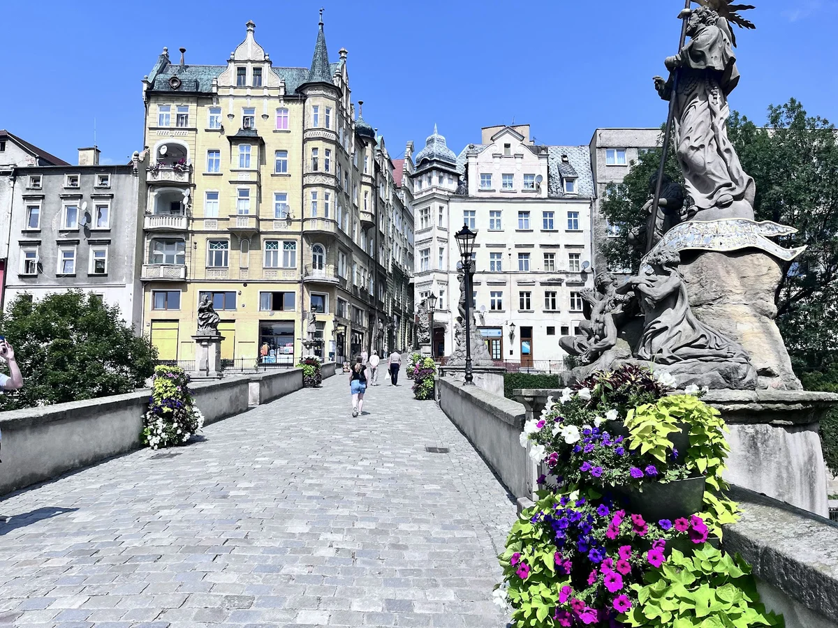 Kamienny most z rzeźbami pod błękitnym niebem pod słońcem.