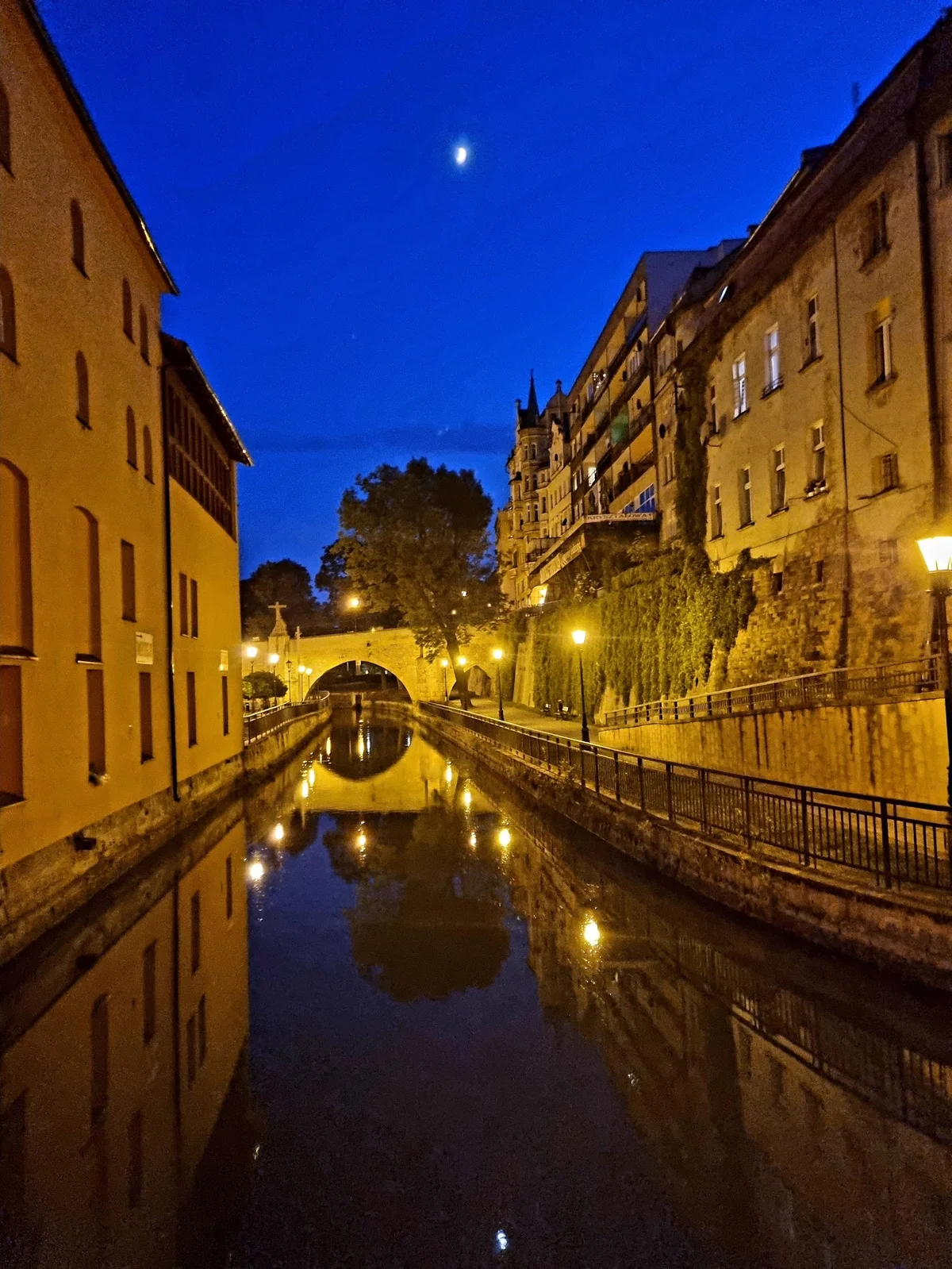 Oświetlona ulica nocą o wysokim standardzie pod niebem o świcie.