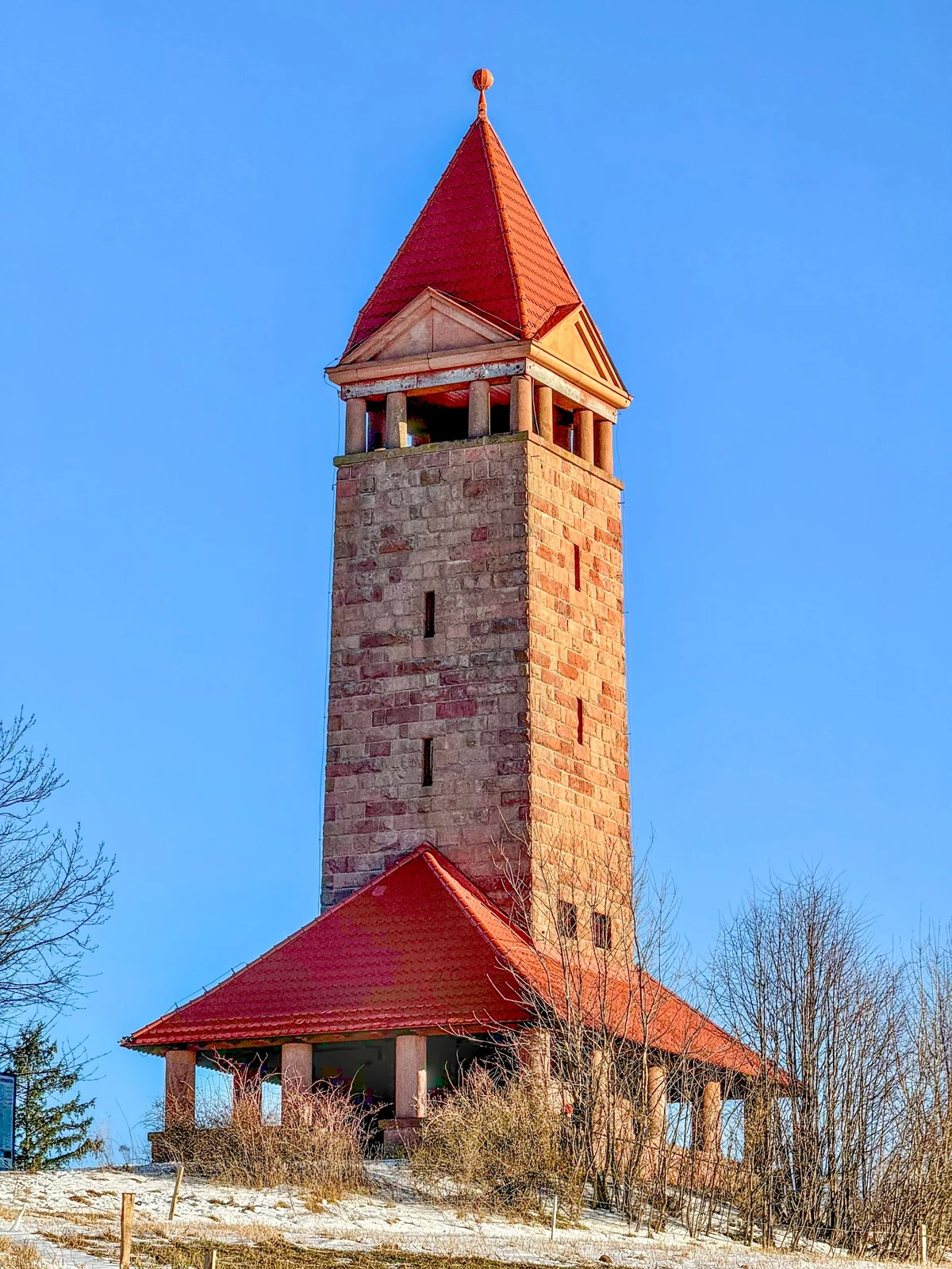Kamienna wieża widokowa o nastrojowej, smukłej architekturze w słońcu.