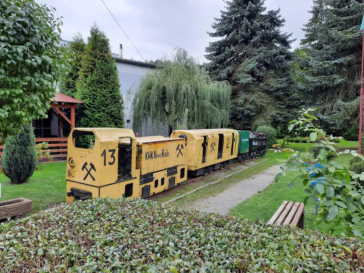 Budynek techniczny kopalni wśród drzew letem.