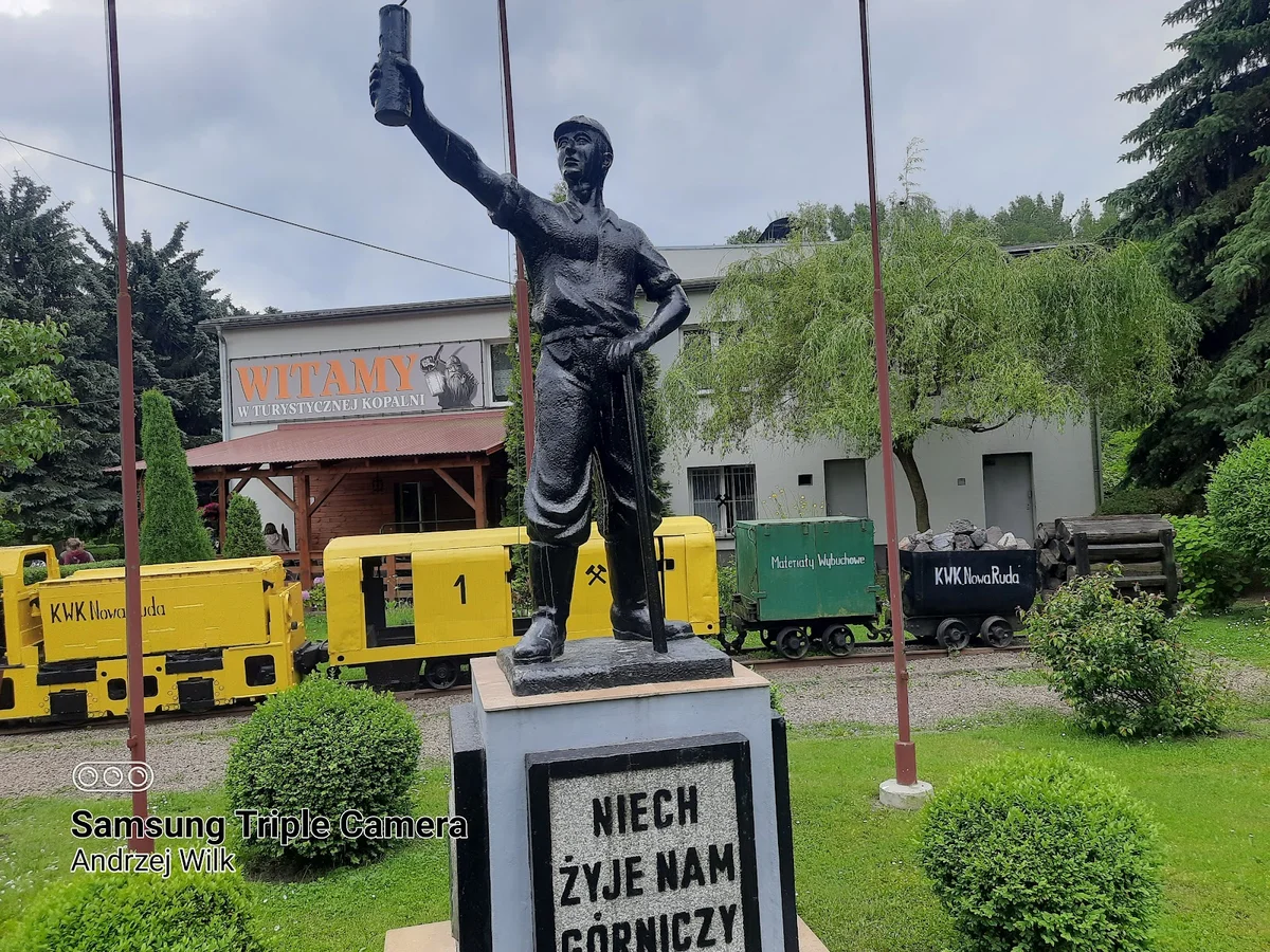 Nastrojowa figura świętego patrona przed kopalnią w słońcu.