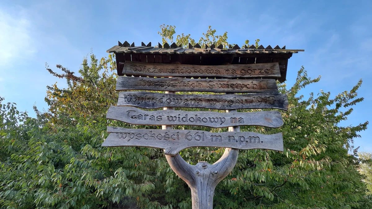 Nietypowa nastrojowa drewniana konstrukcja drogowskazu letem.