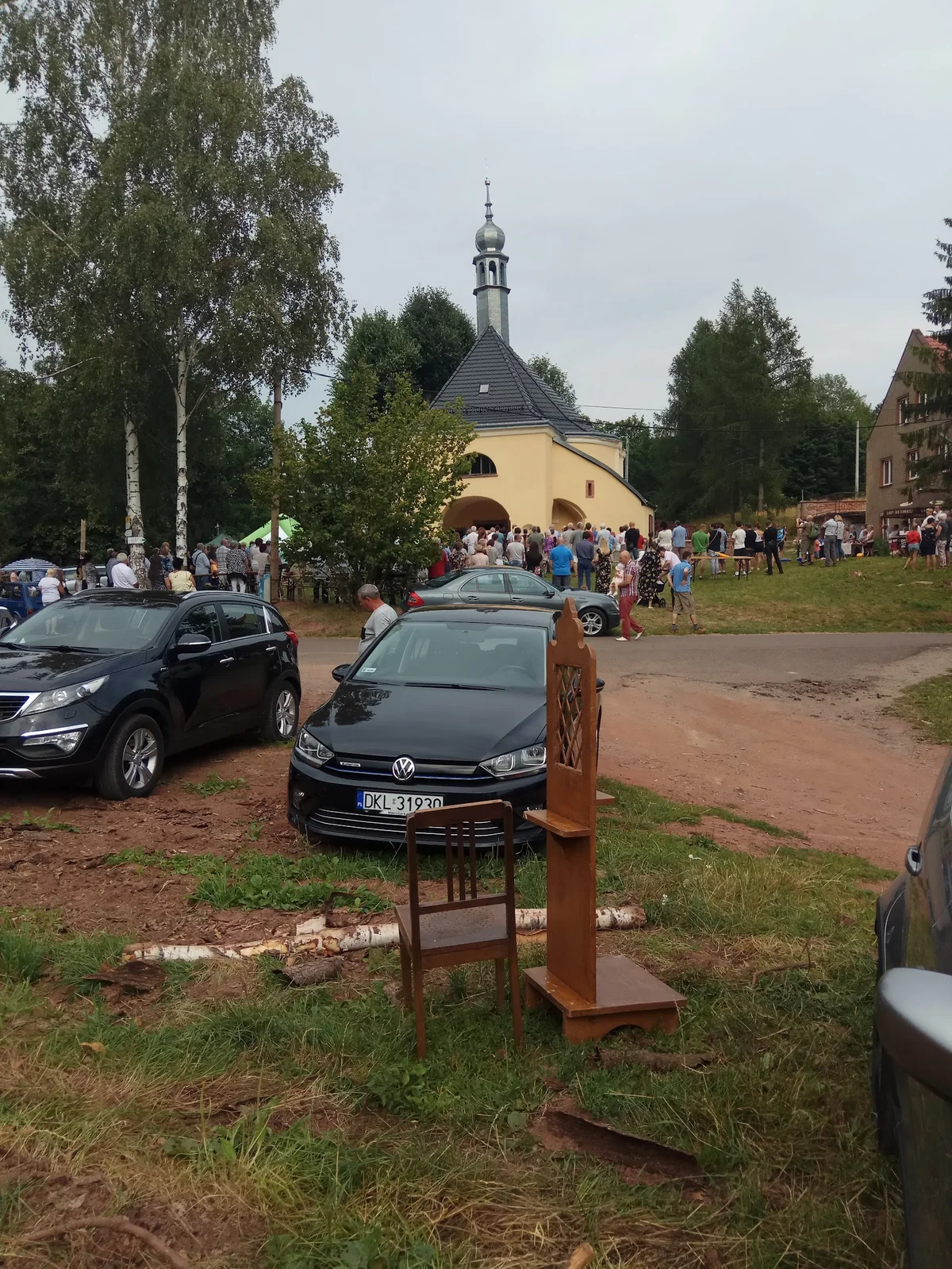 Parking przed nowoczesnym obiektem letnią porą.