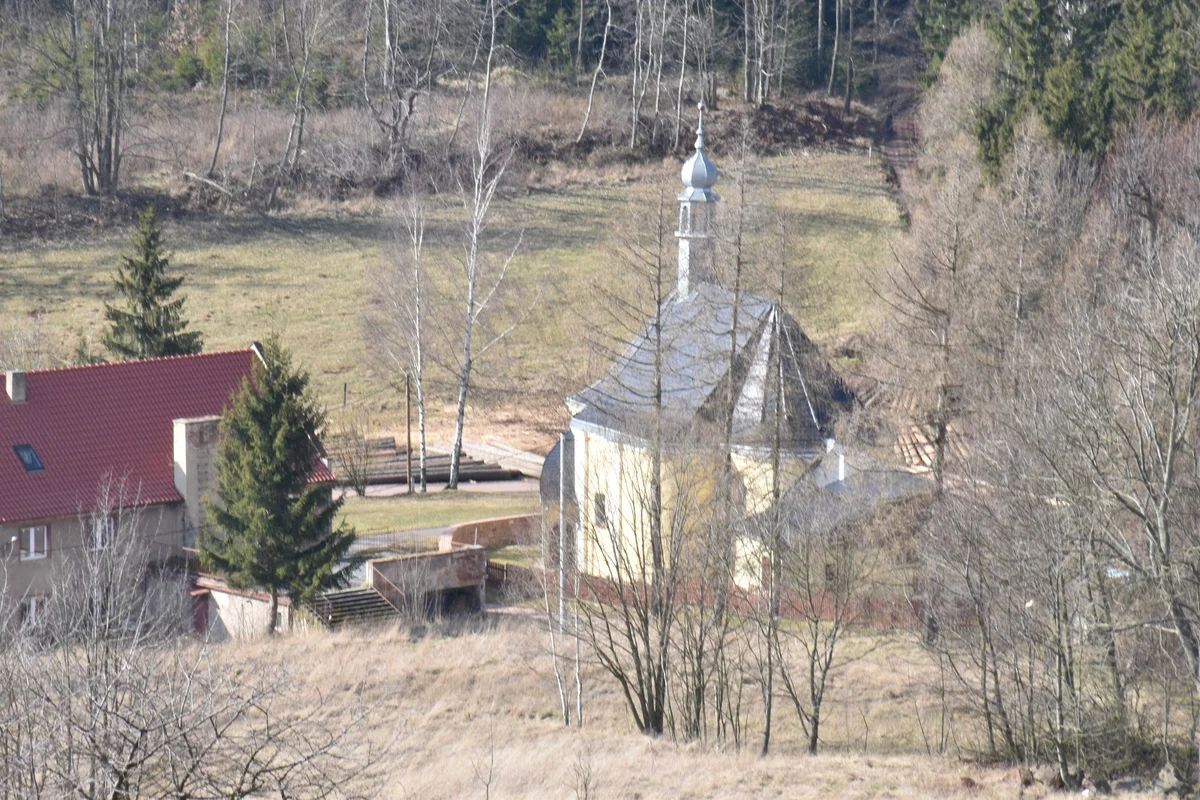 Fragment osiedla o niskiej zabudowie w słońcu.