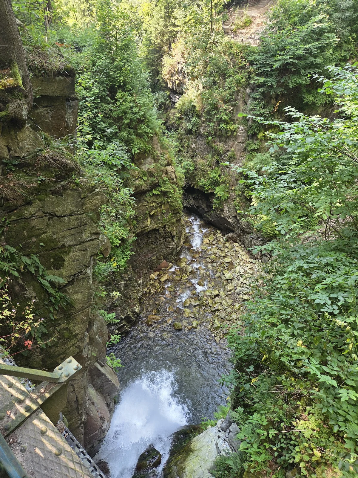 Nastrojowy głośny przepływ wody między kamieniami letnią porą.