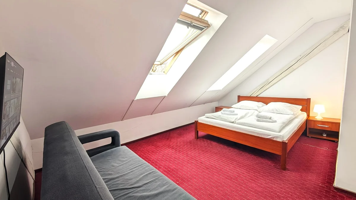 Przytulne wnętrze sypialni na poddaszu letem.