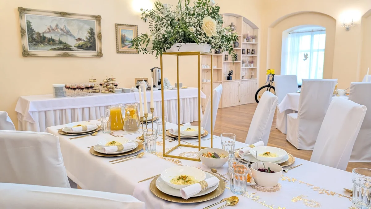 Zastawione stoły w eleganckiej sali restauracyjnej w słońcu.